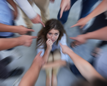ragazza affranta al centro di dita puntate su di lei