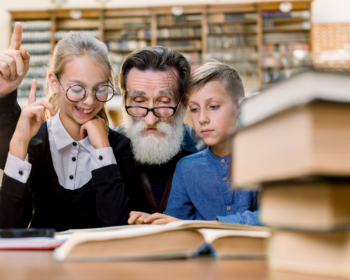 uomo anziano che legge un libro fra due bambini