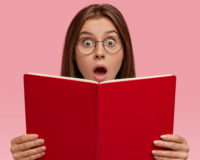 Ragazza che esprime stupore leggendo un libro