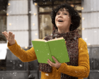 Donna che legge un libro in pubblico all'aperto